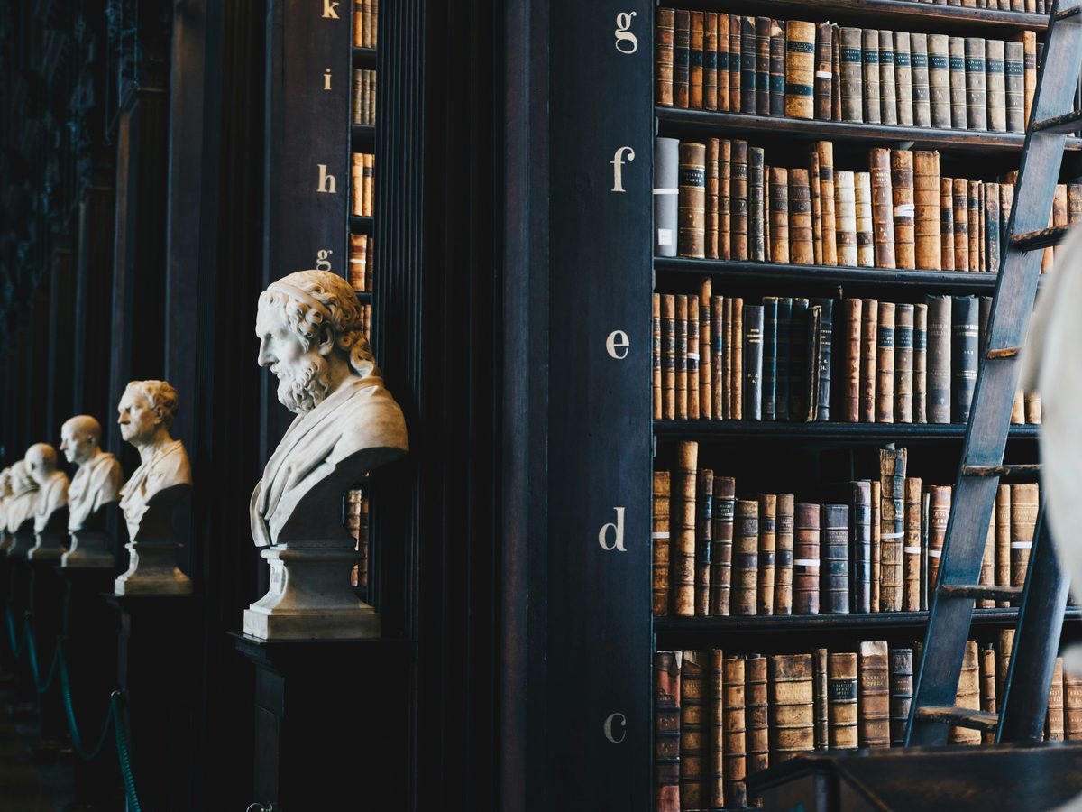 Biblioteca jurídica com bustos e estantes de livros antigos
